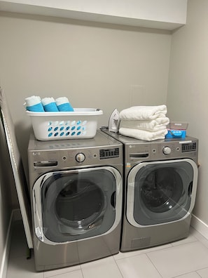A laundry area with two front-loading washing machines and a basket of folded towels. - Spacious 5-bedroom condo, base of Big Cottonwood Canyon in Cottonwood Heights (Cottonwood Heights)
