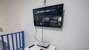 A television mounted on a wall displaying a video game interface. - Have you heard of Santorini? Come experience Santorini in Greece. Themed Hotel (Mérida)