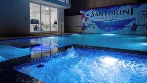 A swimming pool with a view of a building labeled 'Santorini Resort' in the background. - Have you heard of Santorini? Come experience Santorini in Greece. Themed Hotel (Mérida)