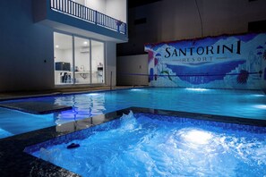 A swimming pool with a view of a building labeled 'Santorini Resort' in the background.