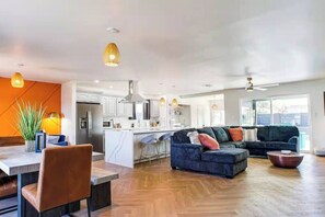 Ein modernes Wohnzimmer mit Küche, Essbereich und Sitzgelegenheit.
