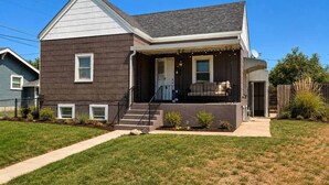 A two-story house with a front porch, a satellite dish, and a small front yard.