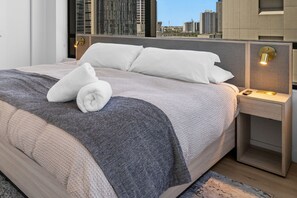 A modern hotel room with a large bed, two bedside tables, and a view of the city skyline. - Luxury Downtown Miami 2BD w/ Free Parking & Pool (Miami)