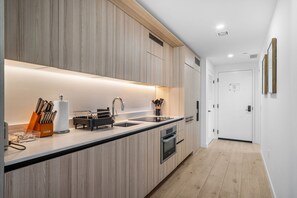 Eine moderne Küche mit Holzschnitzereien, einer Edelstahlspüle und einem eingebauten Ofen.