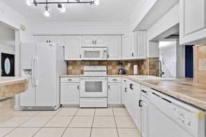 A modern kitchen with white cabinetry, a built-in oven, microwave, and a stainless steel sink. - Large 3-bedroom house lake view Pembroke Pines, Miami (Pembroke Pines)