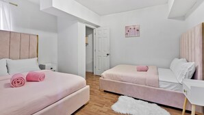 Ein Schlafzimmer mit zwei Betten, einer weißen Tür und einem kleinen weißen Teppich.