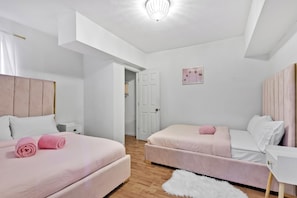 A bedroom with two beds, a white door, and a small white rug. - Large 3-bedroom house lake view Pembroke Pines, Miami (Pembroke Pines)