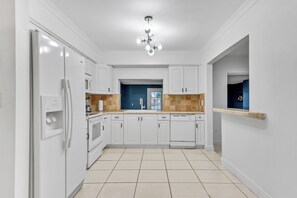 A modern kitchen with white cabinetry, a built-in microwave, and a central island. - Large 3-bedroom house lake view Pembroke Pines, Miami (Pembroke Pines)