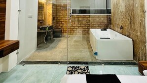 Casa de banho com cabine de chuveiro em vidro, banheira e chão em mosaico.