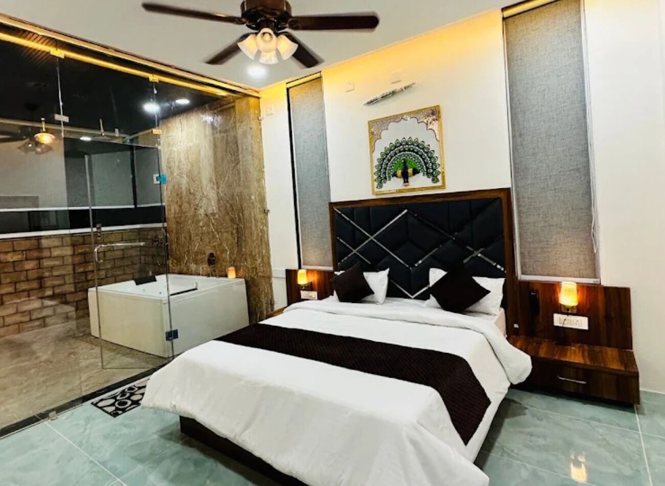 Una habitación de hotel moderna con una cama grande, baño independiente y cabina de ducha de vidrio.