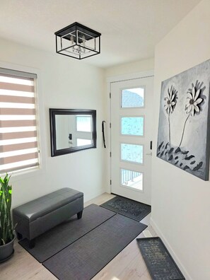 A modern hallway with a bench, a mirror, a door with windows, and a painting. - Modern Luxury Home. High Cilings Near Airport. Netflix, Prime, Disney (Leduc)