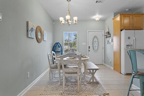 A dining area with a chandelier, a round table, and chairs. - The Camp at Timber Ridge - Direct Water Access (Pass Christian)