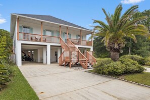 A two-story house with a covered porch and a staircase leading to the upper level. - The Camp at Timber Ridge - Direct Water Access (Pass Christian)