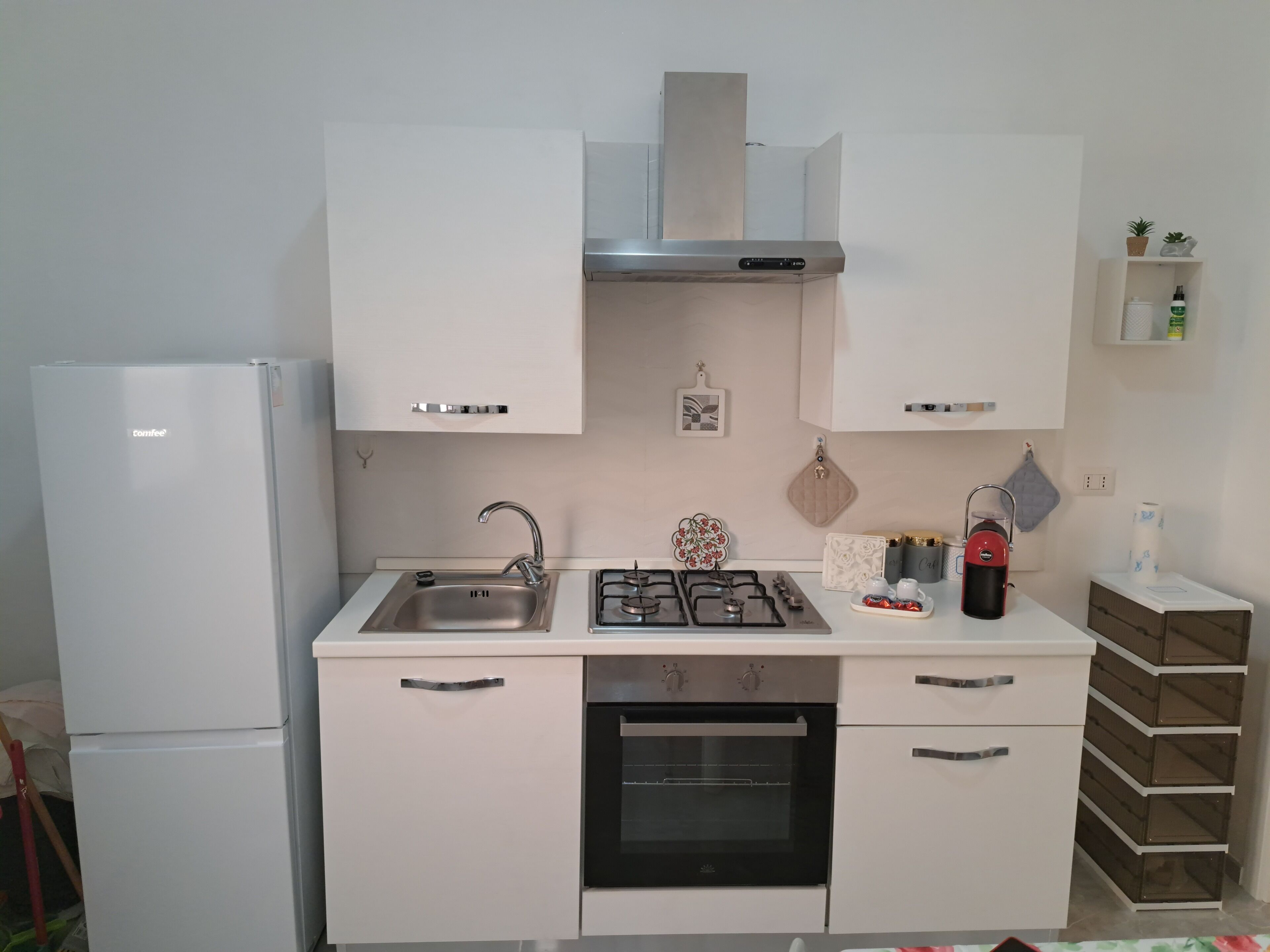 A modern kitchen with a refrigerator, sink, stove, oven, and cabinets.