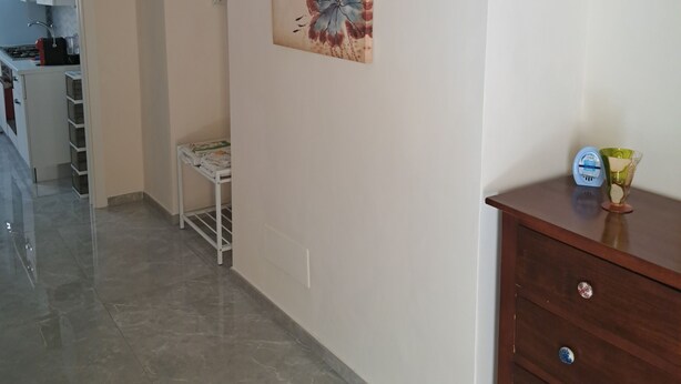 Een keuken met een wit kastje, een witte spoelbak en een fornuis. Er hangt een witte airconditioning aan de muur.