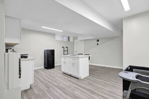 A modern kitchen with white cabinetry, a black refrigerator, and a countertop with a sink.
