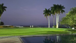 Un parcours de golf avec une piscine et des palmiers.