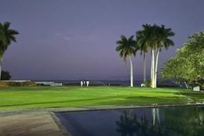 Ein Golfplatz mit Schwimmbad und Palmen.