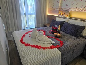 A hotel room with a bed, a nightstand, a window with curtains, and a wall with butterfly decals. - Vrbo suite farmasi arena, Barra 5min, Riocentro, Rock in Rio 10min, Zona Sul 40min (Rio de Janeiro)