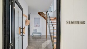 Ein modernes Interieur mit einer Treppe, einer Bank und einem an der Wand befestigten Schild mit der Aufschrift 'SLEAFORTH'.
