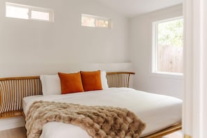 A bedroom with a bed, pillows, a blanket, and a window. - Topanga Canyon Oasis - 3 Homes & Pool - C&C | 12 (Topanga)
