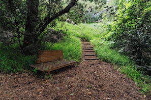A wooden bench in a wooded area with a dirt path leading through the trees. - Topanga Canyon Oasis - 3 Homes & Pool - C&C | 12 (Topanga)