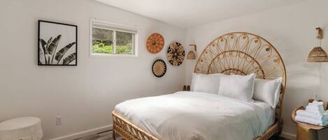 Une chambre à coucher avec un grand lit, une fenêtre et des éléments décoratifs sur les murs.