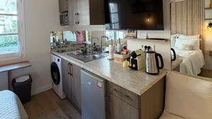 Eine kleine Küche mit Mikrowelle, Spüle und Kaffeemaschine.