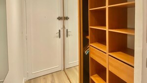 Ein Zimmer mit Holzboden, einer weißen Tür und einer eingebauten Holzregaleinheit.