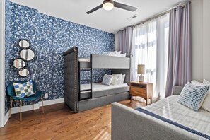 A room with a bunk bed, a desk, a chair, and a window with curtains. - Lux Home Close to Broadway • Rooftop Views & FirePit! (Nashville)