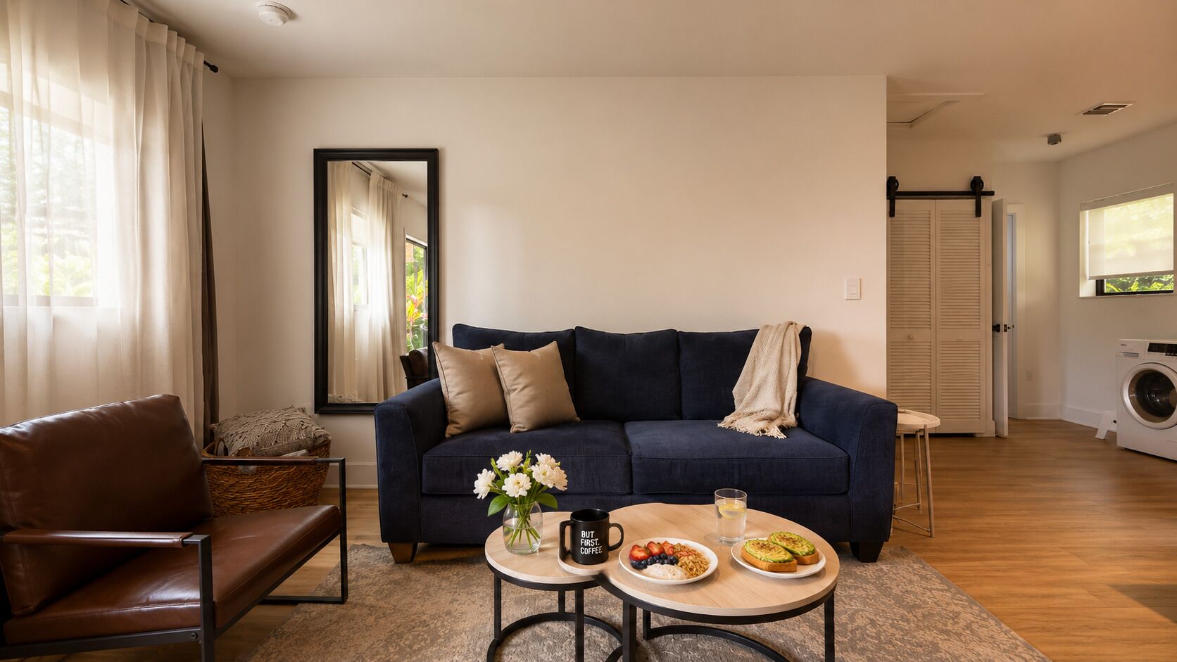 A living room with a sofa, coffee table, and a washing machine in the background.