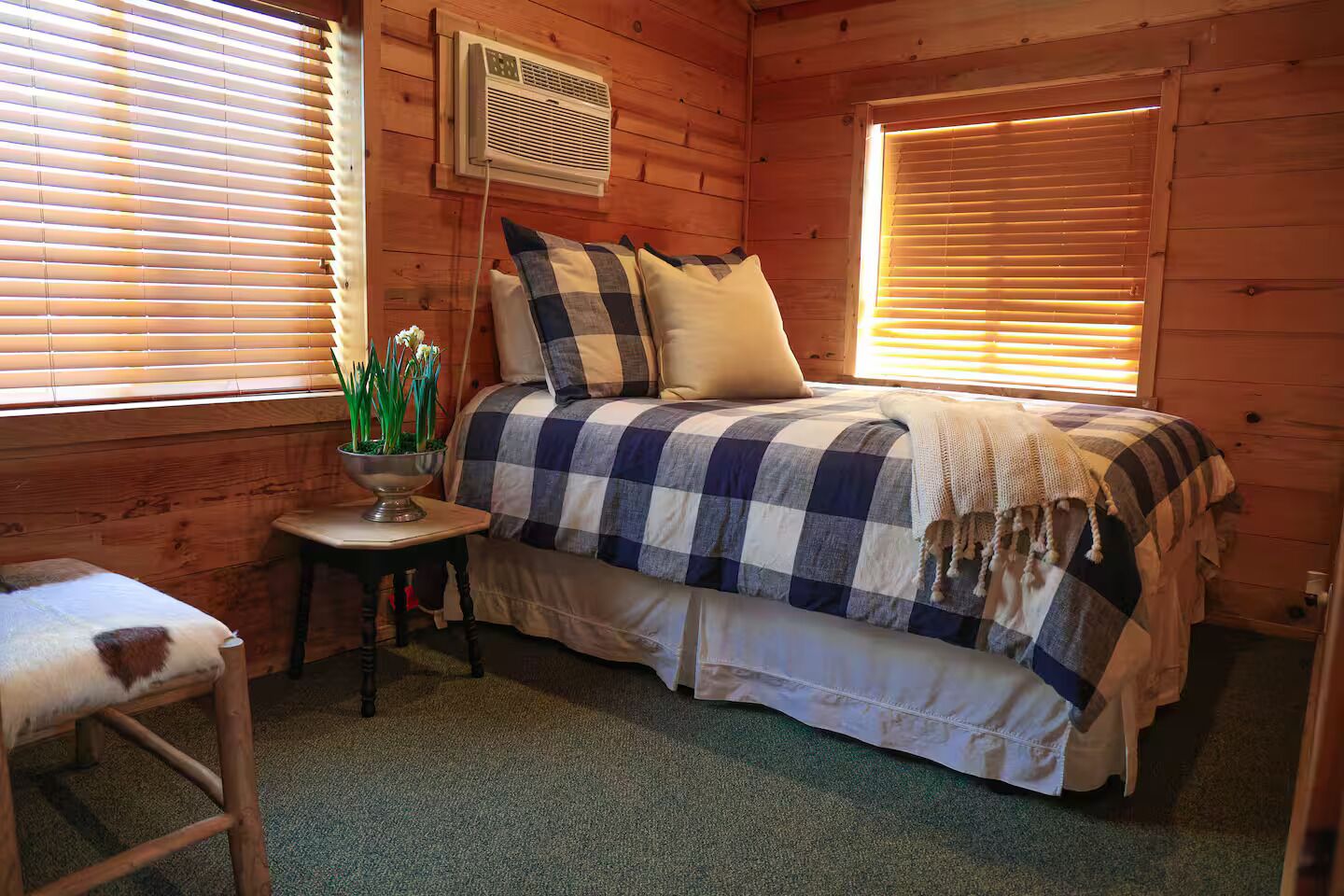 A cozy bedroom with a bed, a small table, and a chair.