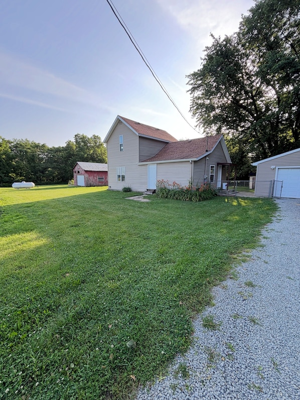 A residential property with a two-story house, a detached garage, and a fenced yard.