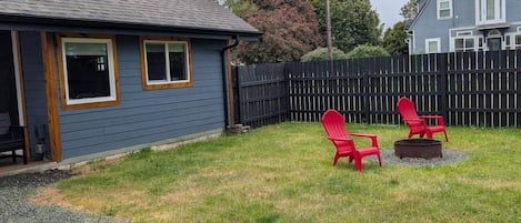 A house with a blue exterior, a wooden deck, and a gravel driveway.