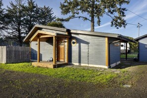 Un petit bâtiment d’un seul étage, doté d’un porche, d’une porte et d’une fenêtre.