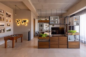 A modern living room with a foosball table, a TV, and a world map light. - Cómodo y moderno en col. Amerciana Mariachiloft (Guadalajara)