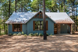 Eine rustikale Holzhütte mit Metalldach, Holzverkleidung und einer Veranda.
