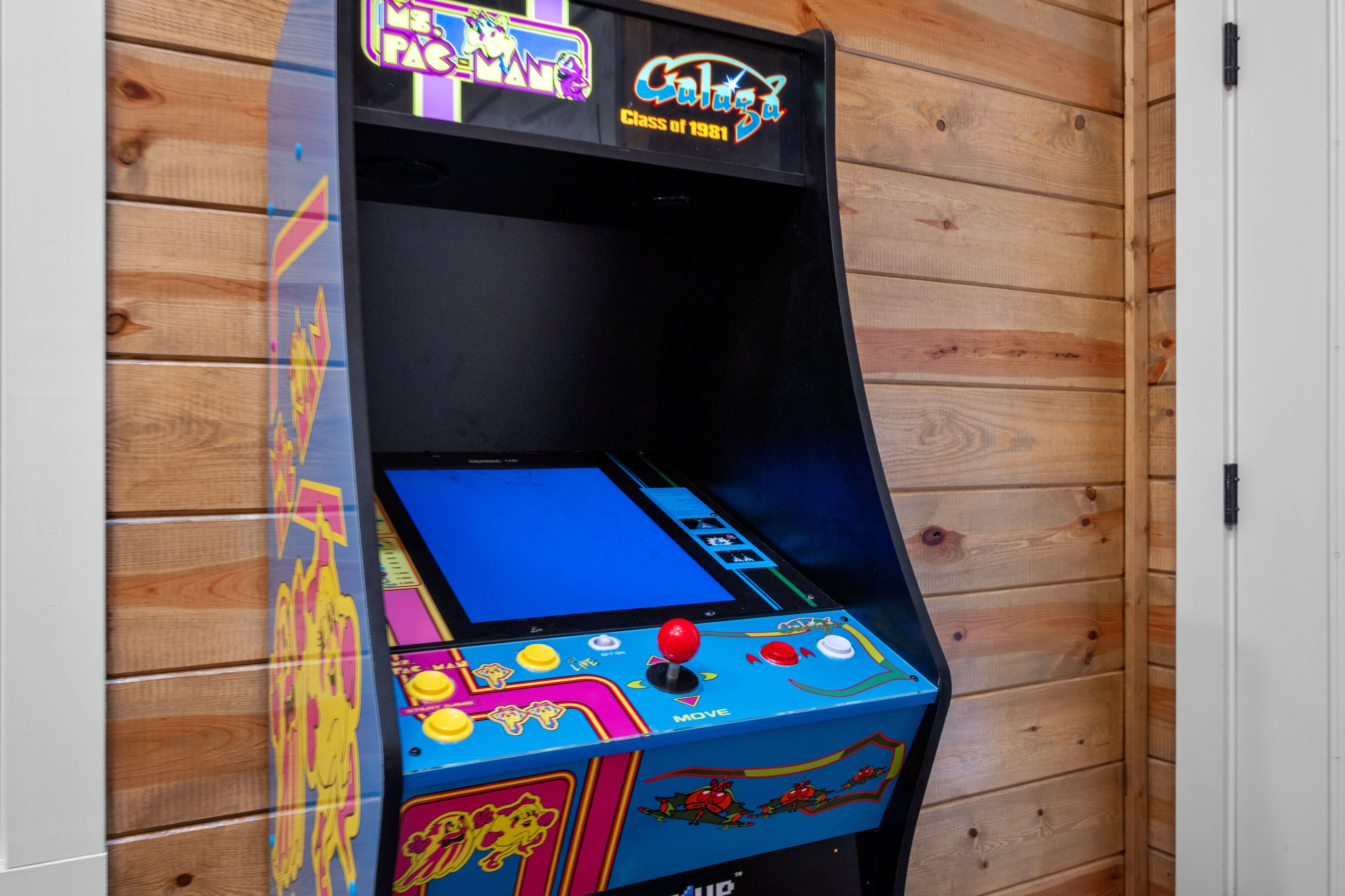 Una máquina de videojuegos retro con gráficos coloridos y botones.