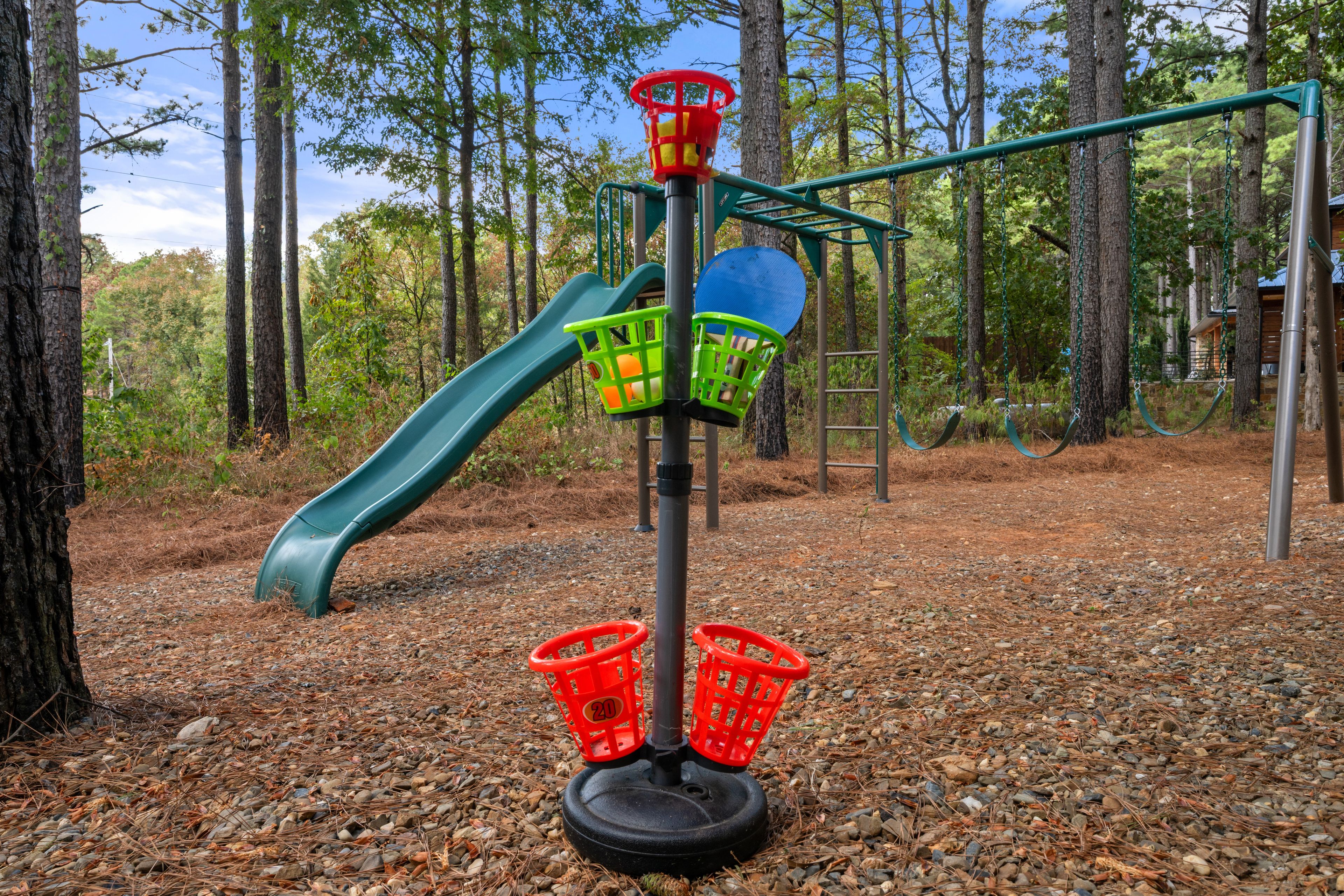 Une aire de jeux avec un toboggan, des balançoires et une structure d’escalade.