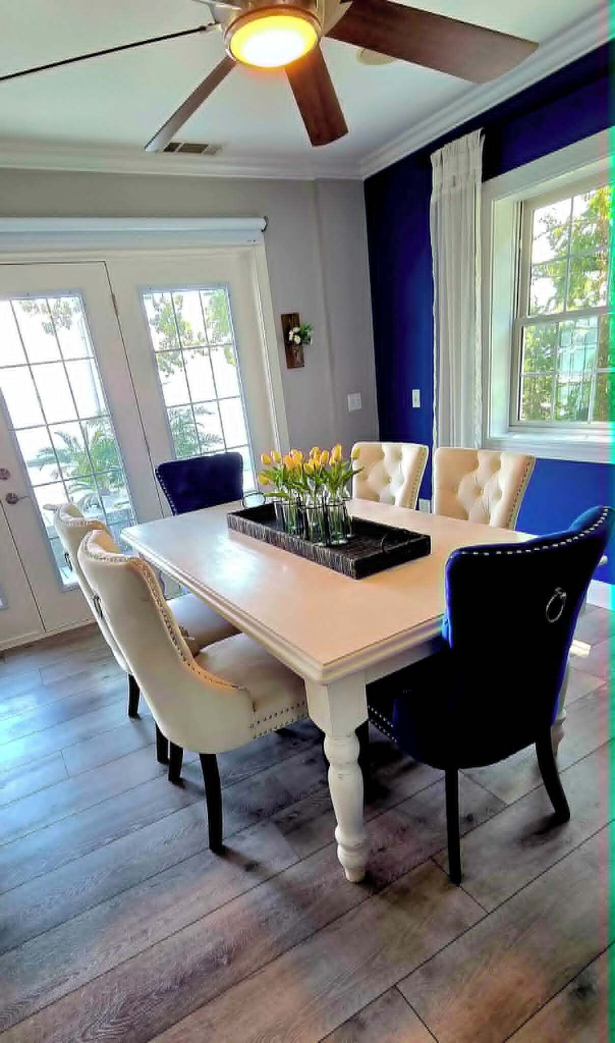A dining area with a table, chairs, and a ceiling fan.