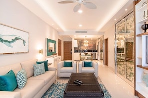 A modern living room with a sofa, chairs, a coffee table, and artwork on the walls. - 2-bedroom condo in superb Cabo San Lucas with AC and gym (Cabo San Lucas)