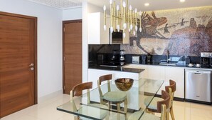 Eine moderne Küche mit einem Glastisch, Holzstühlen und einer Mosaik-Spritzschutzwand.