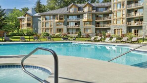 Ein Hotel mit Pool, Liegestühlen und Blick auf die Berge.