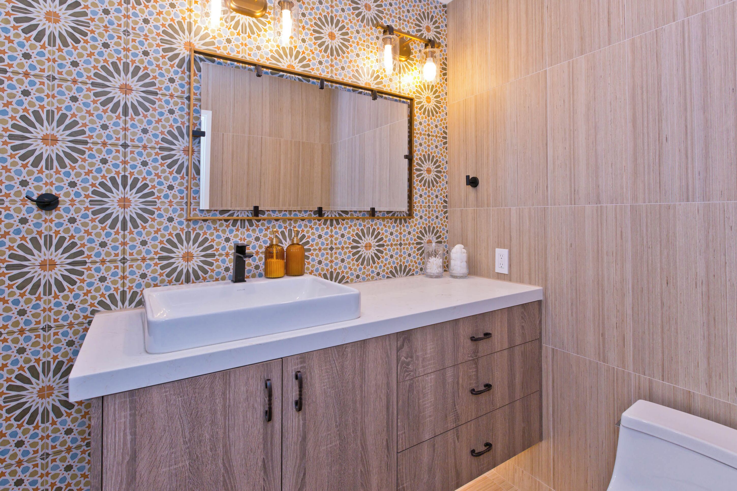 A bathroom with a white sink, wooden cabinets, and a mirror above it.