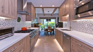 Una cocina moderna con armarios de madera, un microondas Bosch y un comedor con vistas.