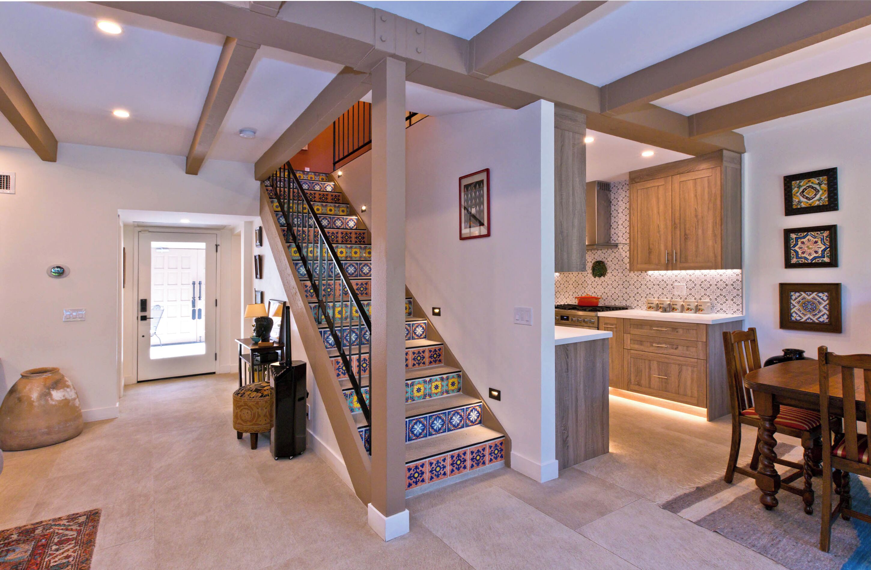 A modern interior with a staircase, a kitchen, and a dining area.