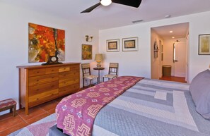 A bedroom with a bed, dresser, chairs, and artwork on the walls. - Stylish Spanish townhome w/ mountain views, pool & spa in South Palm Springs (Palm Springs)