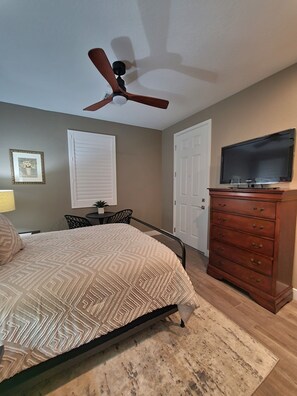 A bedroom with a bed, dresser, ceiling fan, and a TV. - Cozy 1- large bedroom, private bathroom, with mini kitchen, (las vegas)