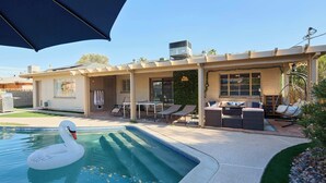 A residential property with a swimming pool, outdoor seating, and a pergola. - Backdrop - Private Pool - Mins to Old town (Scottsdale)