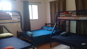 Un dormitorio con literas, una ventana con cortinas y suelo de baldosas.